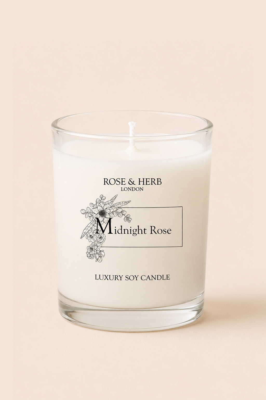 A white wax candle in a clear glass jar with a wick, labeled 'Midnight Rose' by Rose & Herb London, set against a solid pale beige background.