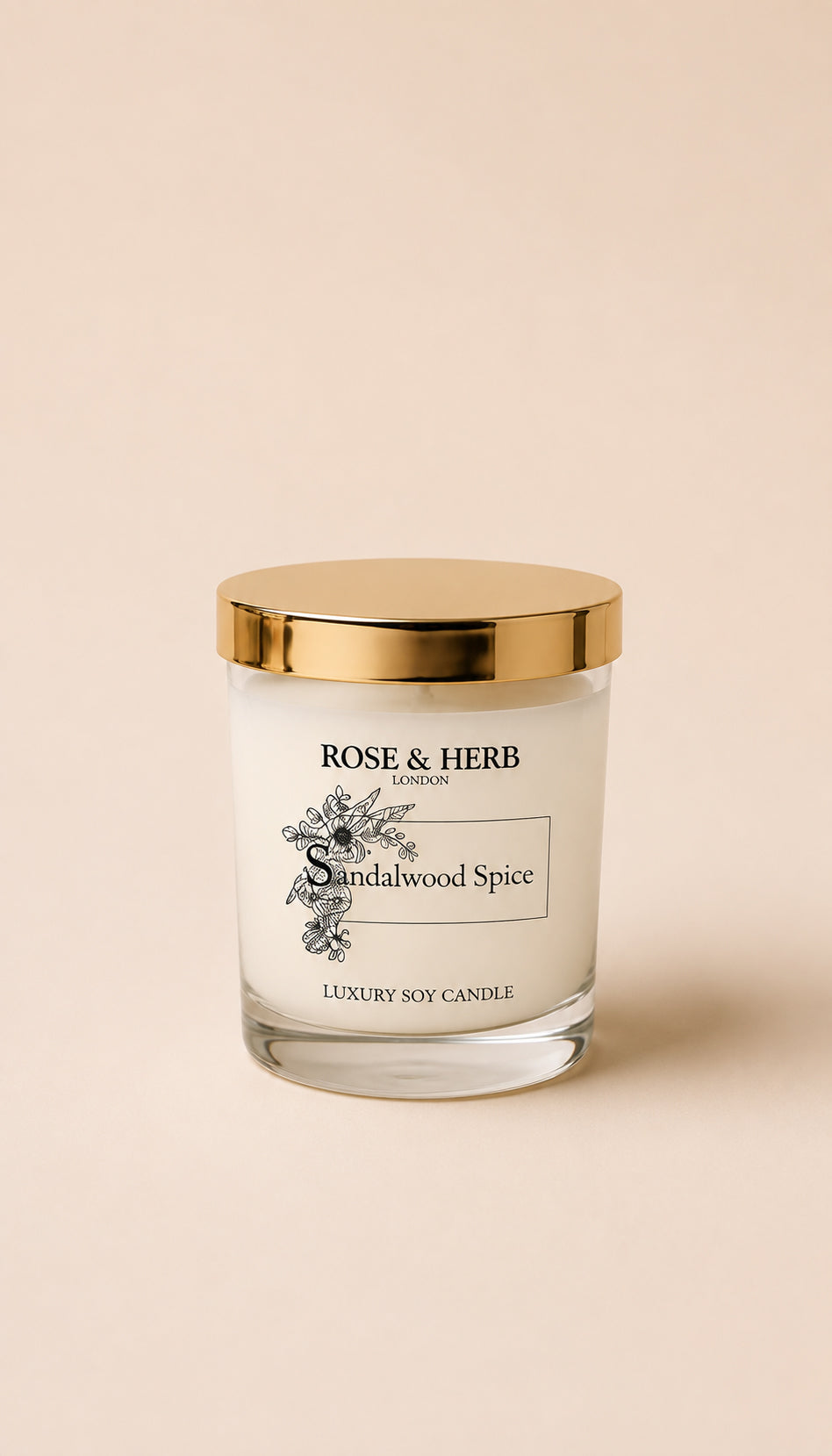 A Rose & Herb London Sandalwood Spice luxury soy candle in a clear glass jar with a gold lid, set against a solid beige background.